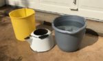 Buckets and an old tea pot used to harvest rainwater